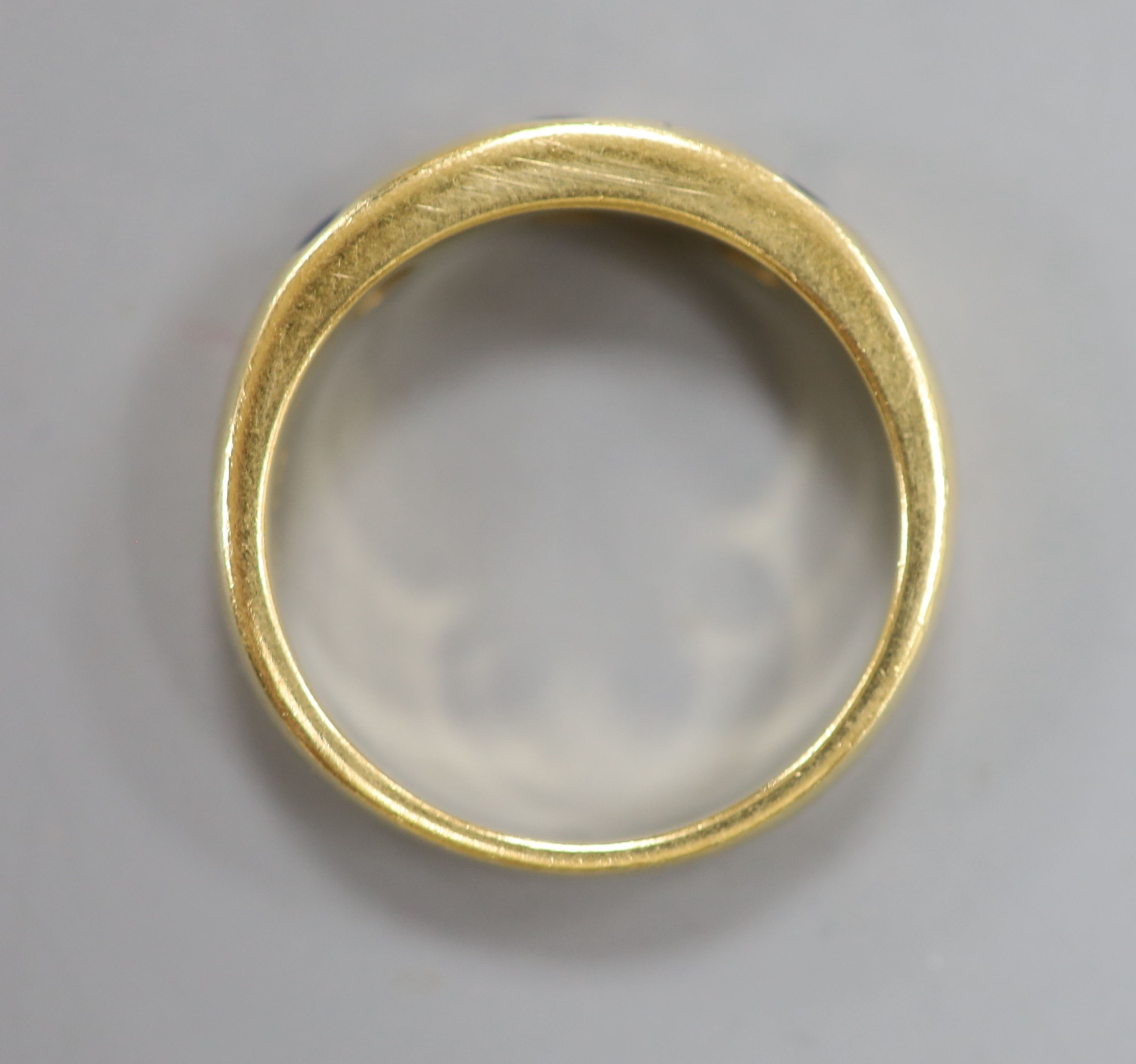 A modern 750 yellow metal, sapphire and diamond set half hoop ring, size N/O, gross 5.6 grams.